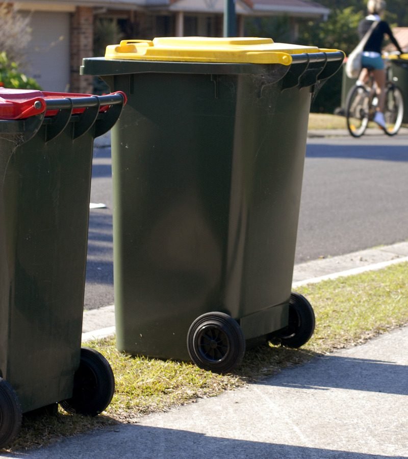 Two rubbish bins in Australia. Red lid is rubbish, yellow lid is recycling.